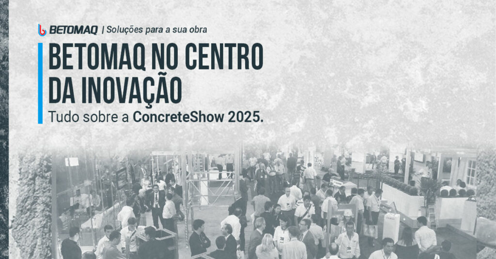 Pessoas circulam e conversam em evento ou feira industrial, cercadas por estruturas metálicas e estandes. Imagem em tons de cinza.