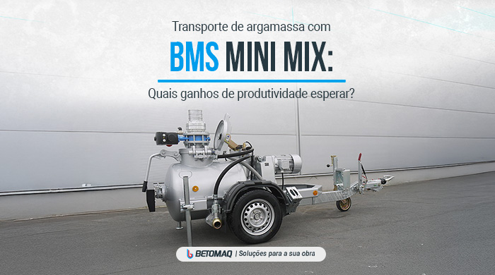 Máquina de transporte de argamassa metálica com rodas e conexões hidráulicas, posicionada em área externa pavimentada.