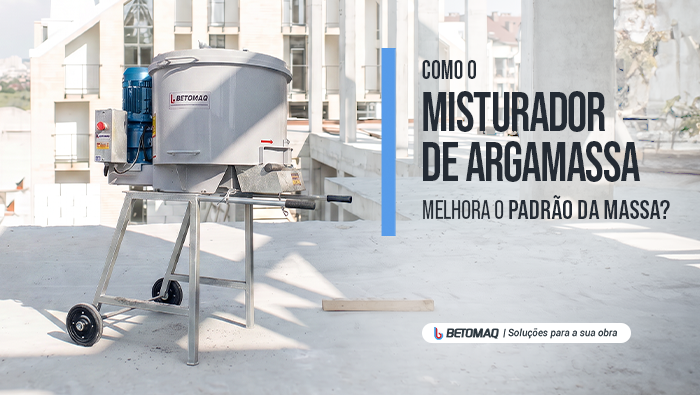 Misturador de argamassa industrial sobre estrutura metálica com rodas, posicionado em uma obra de construção civil com estrutura de concreto ao fundo.